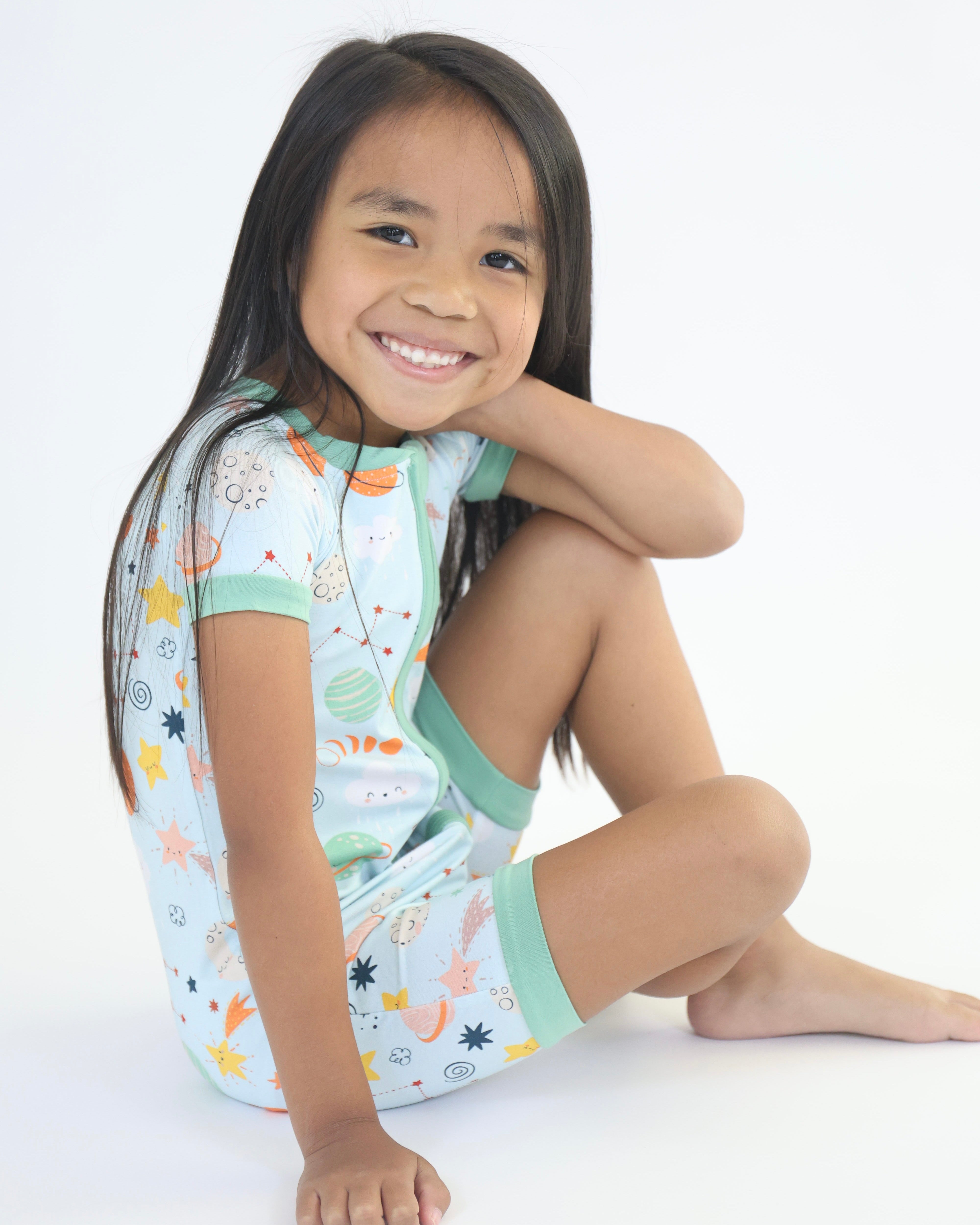 Cute child wearing Cosmic Short Zipp Romper in playful space print, showcasing comfort and style.