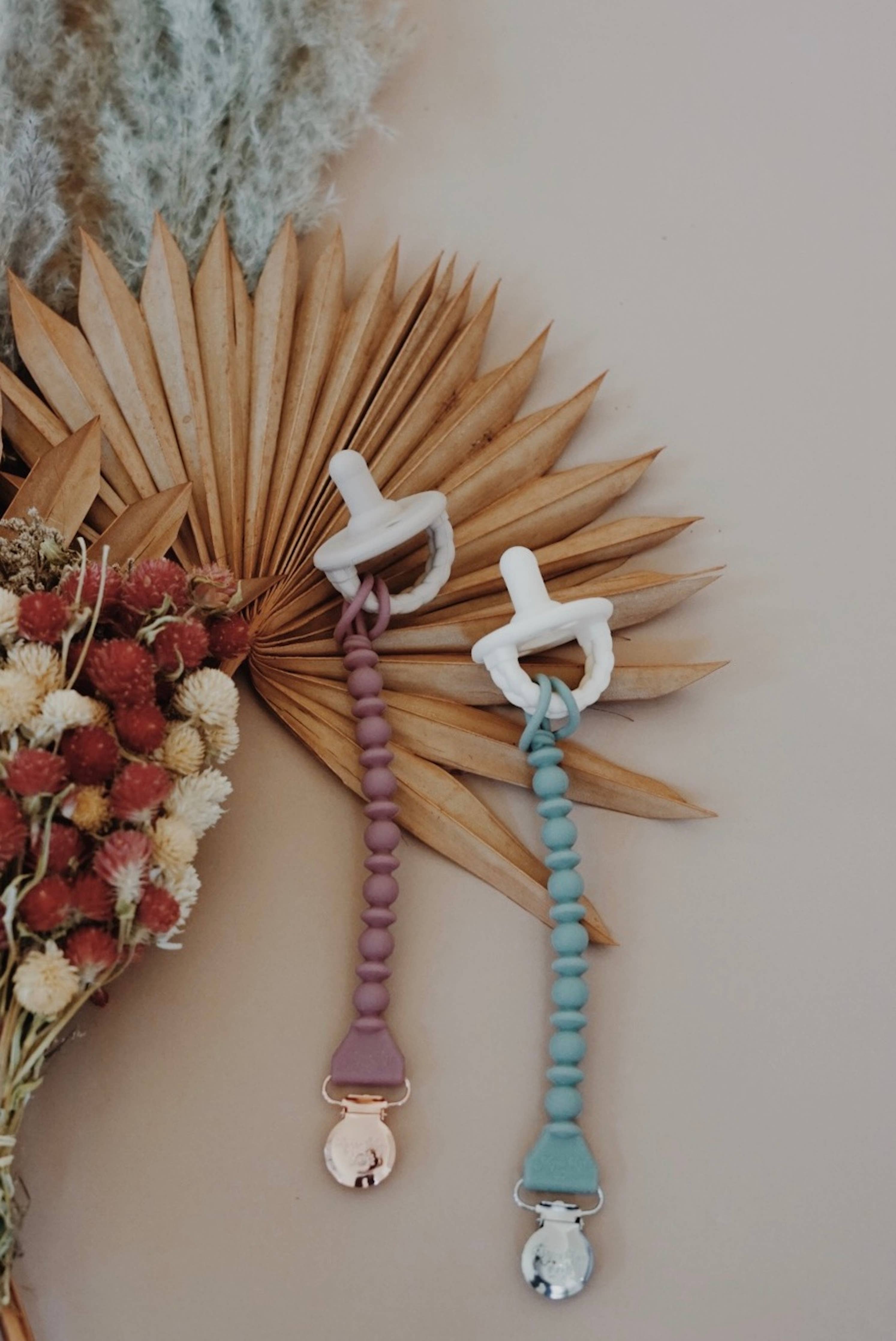 Sweetie Strap™ silicone pacifier clips in pastel colors, stylish and functional, perfect for keeping pacifiers secure.