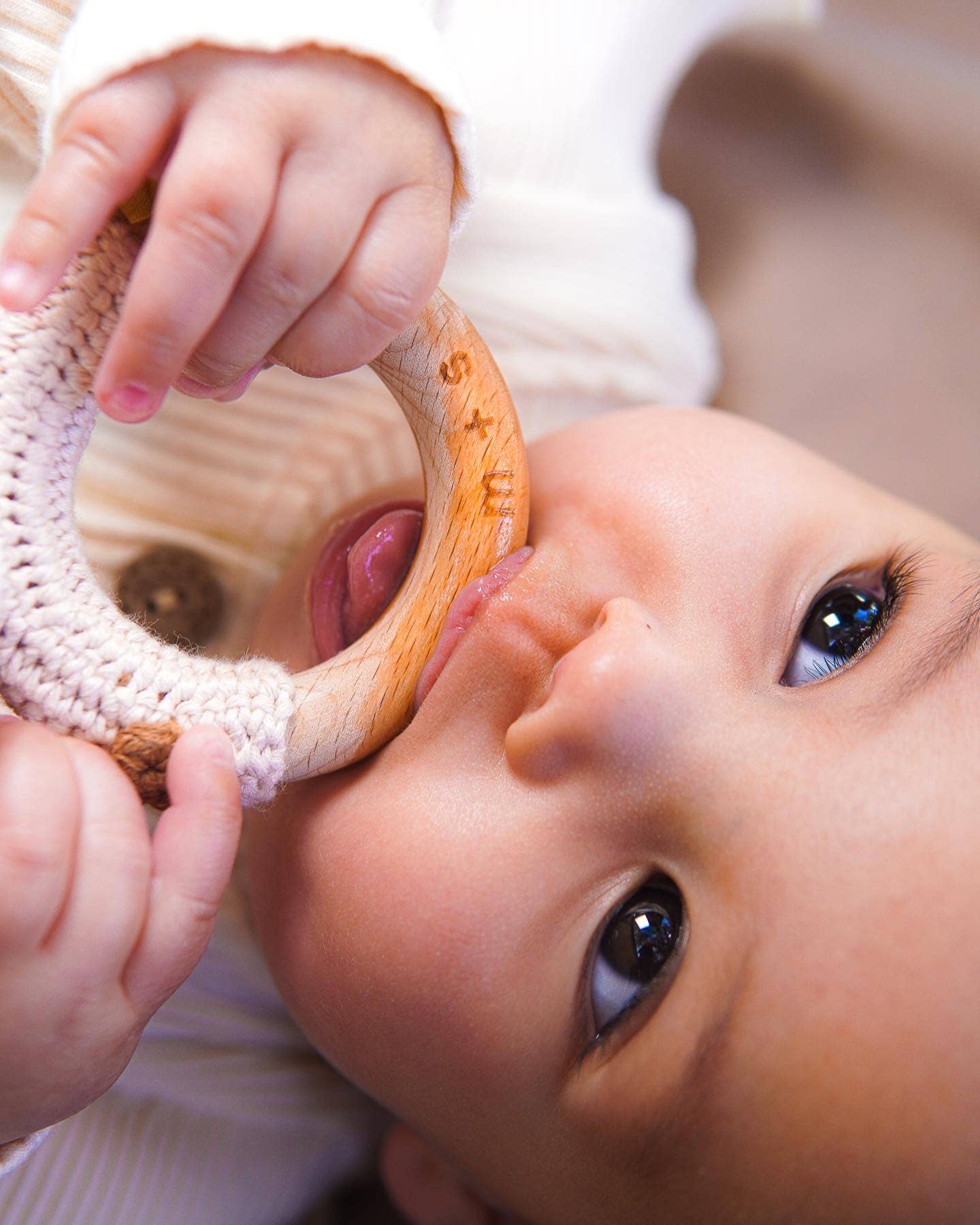 Adorable baby exploring a handmade crochet rattle, perfect for sensory play and early development.