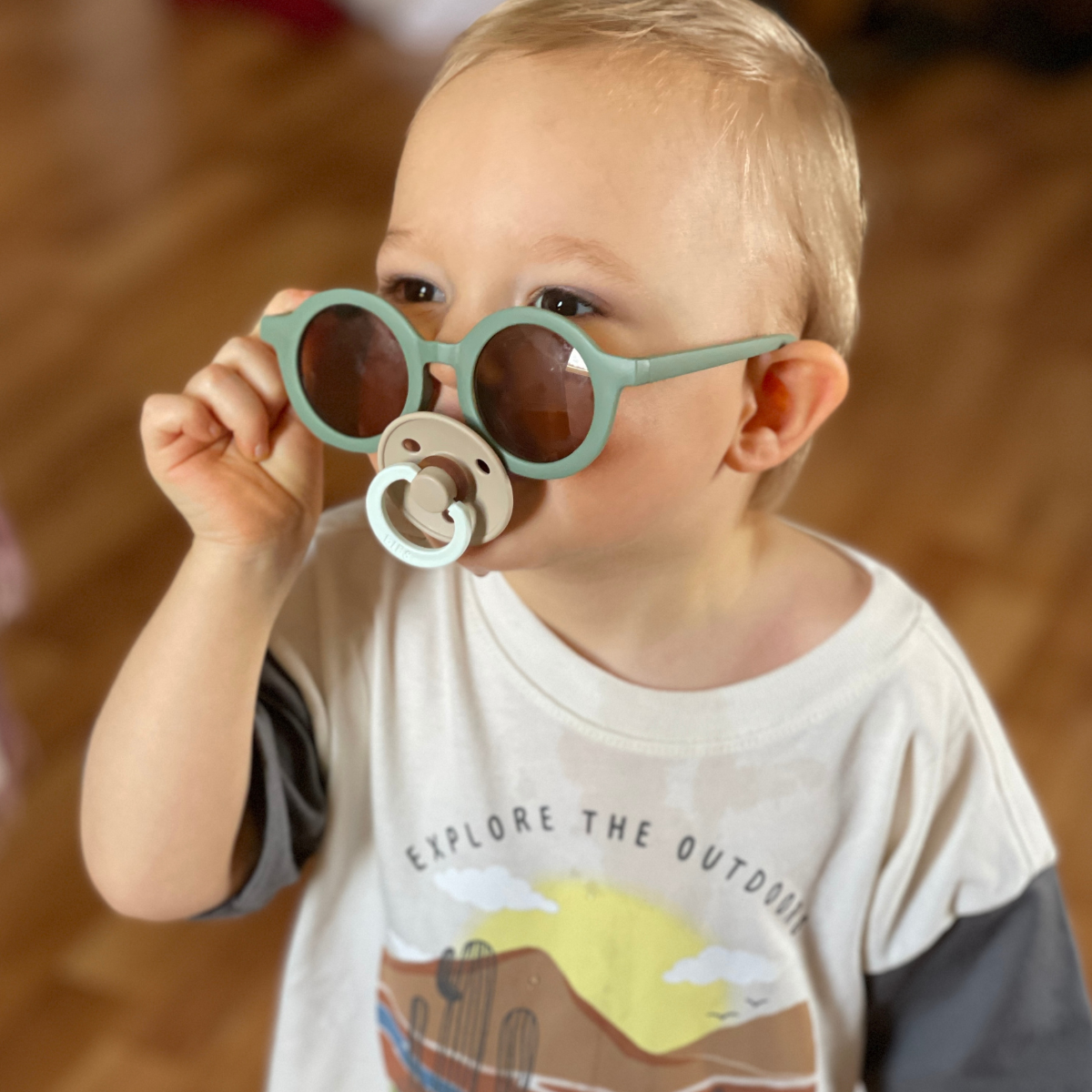 Toddler wearing Bug + Bean Kids Thyme Green Recycled Plastic Sunglasses, showcasing stylish and sustainable eyewear for children.