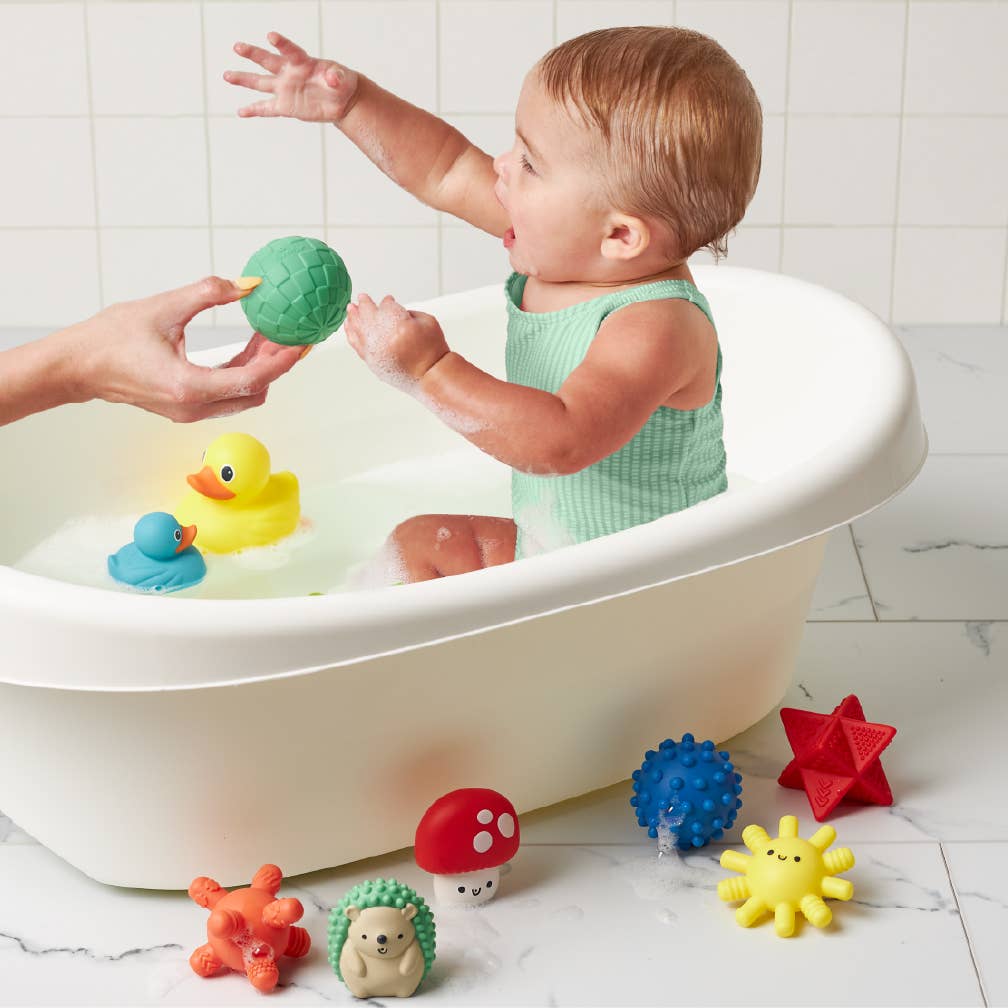Happy toddler enjoying bath time with colorful Itzy Splash Gift Set™ water toys for fun and play!