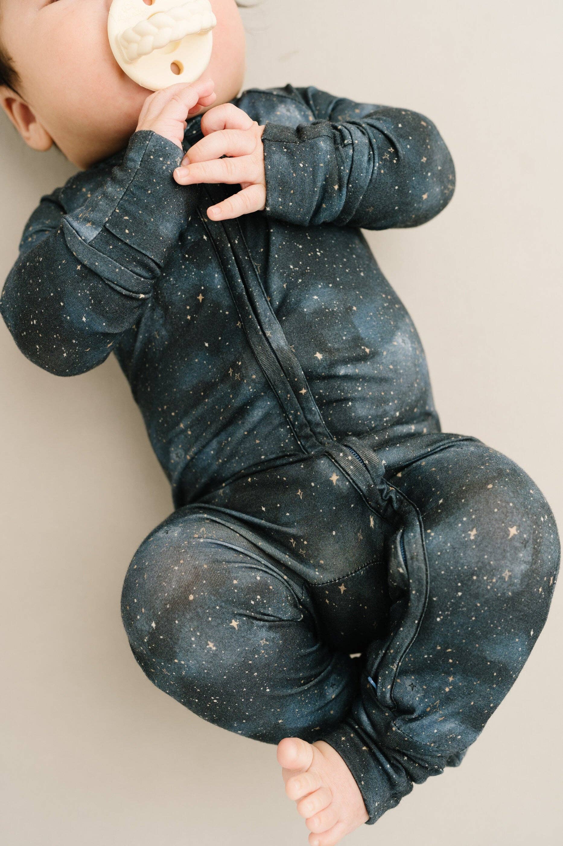 Baby wearing Moonlight Bamboo Sleeper from Little One Shop, starry design for 6-12 months, showcasing softness and comfort.