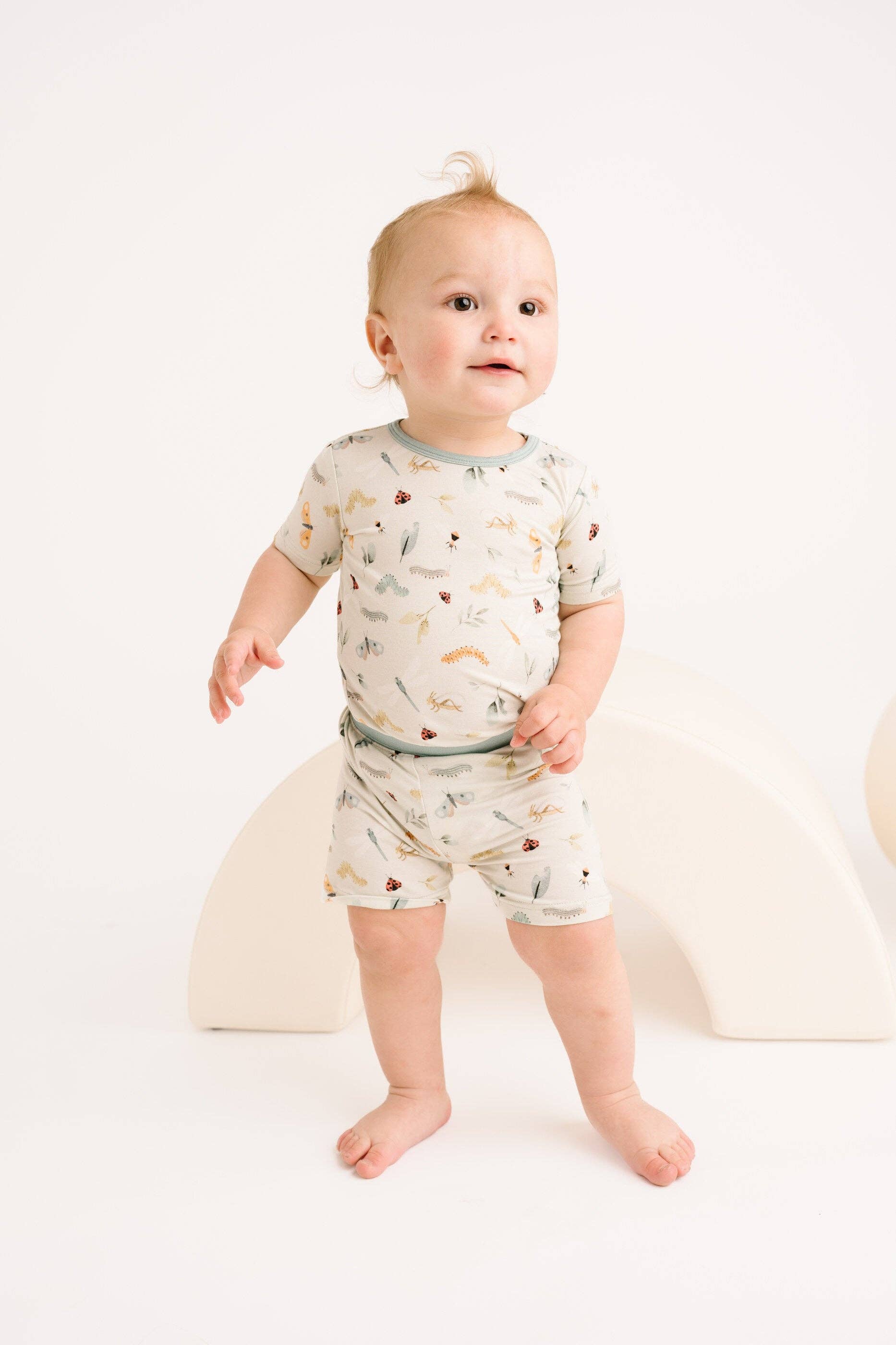 Adorable baby wearing Little One Shop Bug Buddies bamboo shorts set, ages 12-18 months, showcasing stylish and comfy outfit.