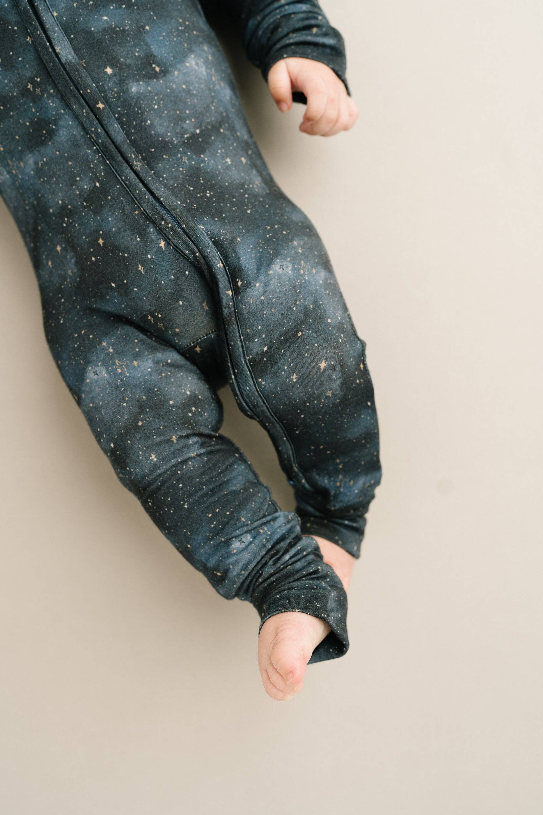 Baby wearing Moonlight Bamboo Sleeper by Little One Shop, showcasing the starry design, perfect for 6-12M nighttime comfort.