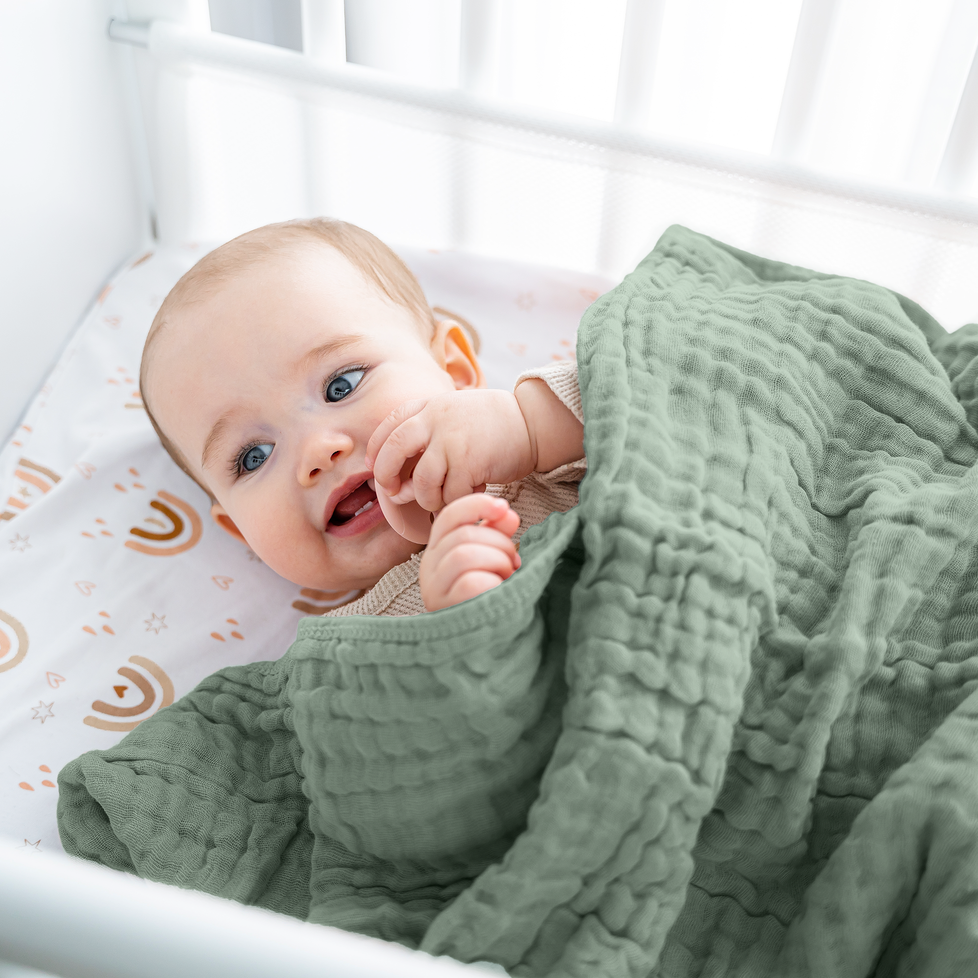 Adorable baby wrapped in soft muslin cotton blanket, smiling and cozy in crib.