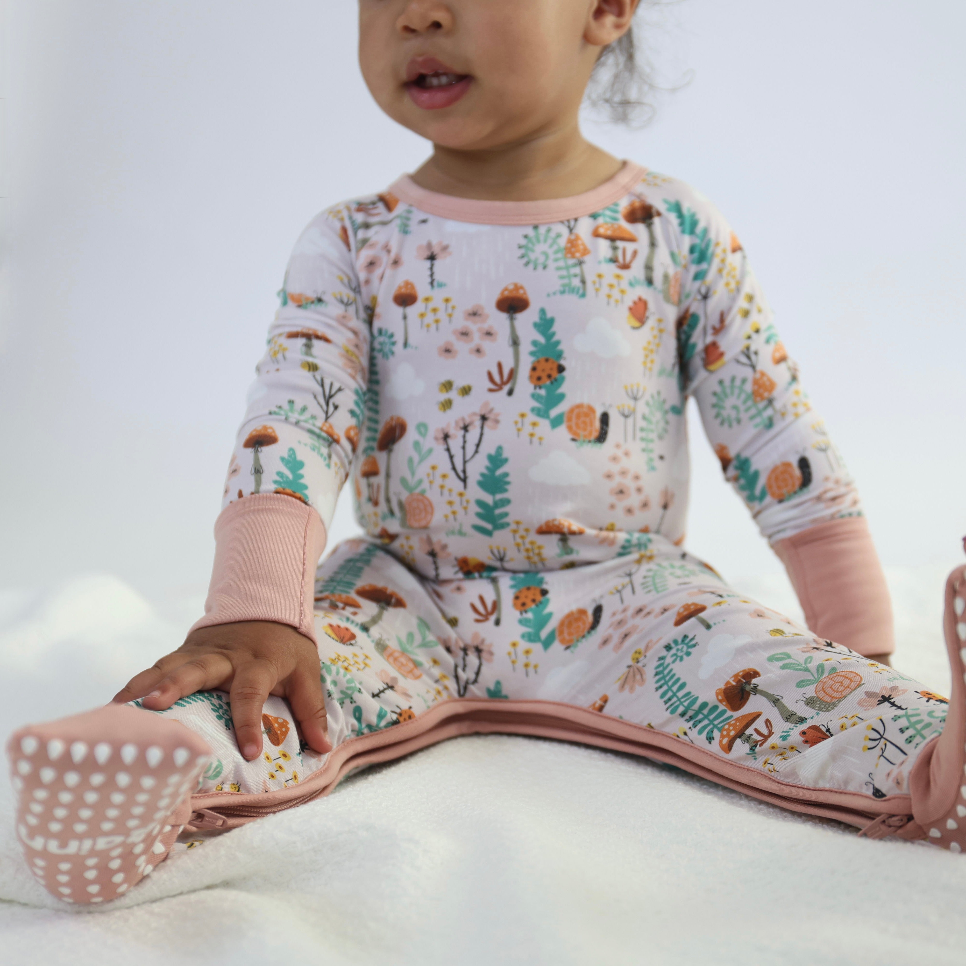 Toddler wearing Bamboo crescent zipp jammies in fern pattern, showcasing breathable, hypoallergenic fabric for comfortable sleep.