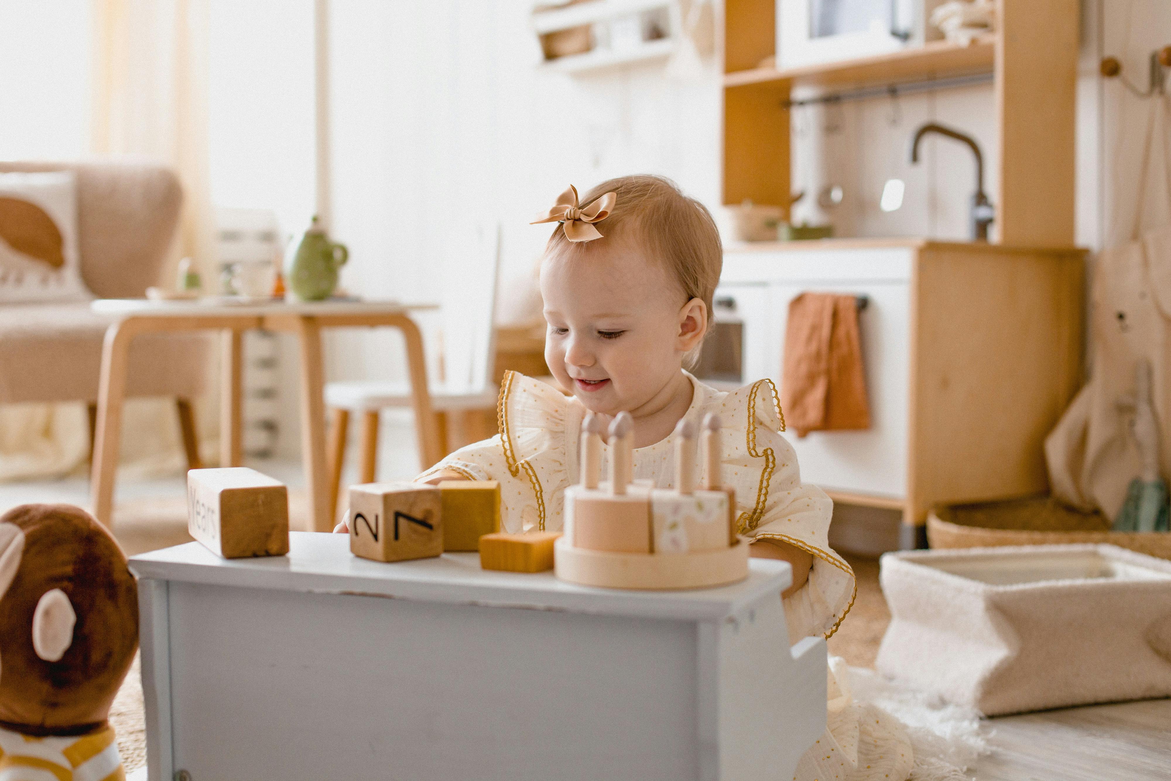 Happy toddler playing with colorful blocks and toys in a bright, cozy playroom.